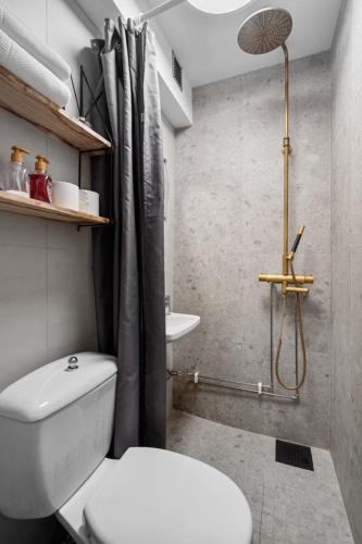 a bathroom with a white toilet and a shower at BraMy Apartments The Cozy View in Tromsø