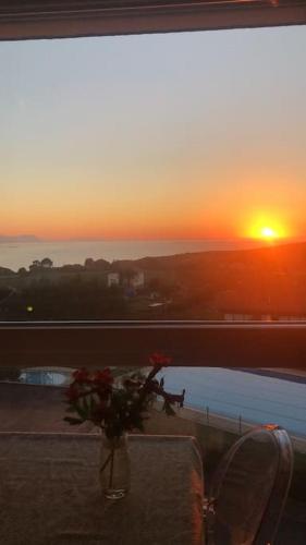 a vase of flowers sitting on a table with a sunset at Apto vacacional en Barrica in Barrika