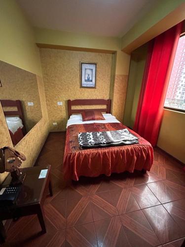 a bedroom with a bed with a redspread on it at Aquarium in Lima