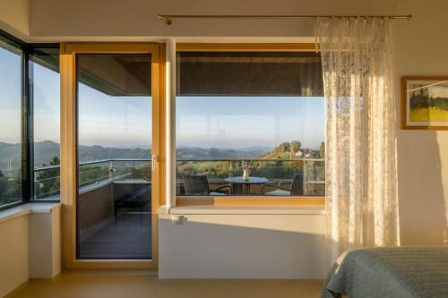 a bedroom with a view of a balcony at WURZENBERG Hotel Lodges Südsteiermark in Gamlitz