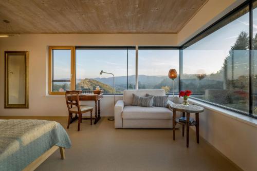 a bedroom with a bed and a couch and a table at WURZENBERG Hotel Lodges Südsteiermark in Gamlitz