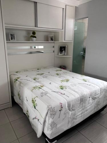 a bedroom with a bed with a white comforter at Recanto dos pássaros in Penha