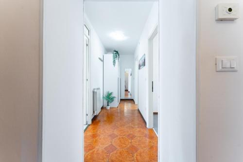 a hallway with white walls and orange tile floors at 5 minuti da Asiago - Garage e BBQ in Roana