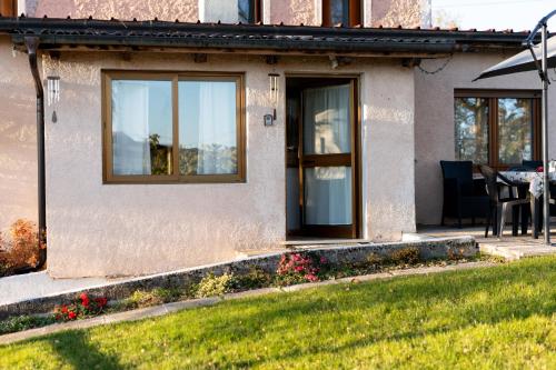 a house with a door and a table and chairs at 5 minuti da Asiago - Garage e BBQ in Roana