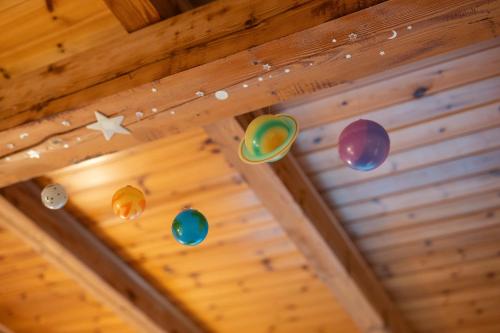 a ceiling with colorful balloons hanging from a ceiling at 5 minuti da Asiago - Garage e BBQ in Roana