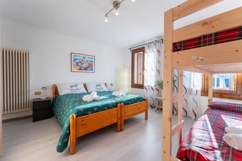 a bedroom with a bed and a bunk bed at 5 minuti da Asiago - Garage e BBQ in Roana