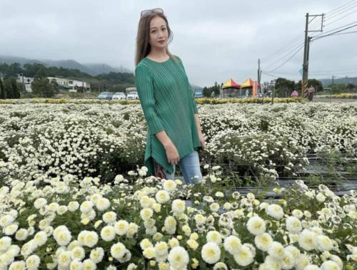 a woman standing in a field of white flowers at Miaoli Sanyi Shantongyazhu Homestay in Sanyi