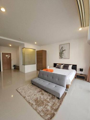 a large bedroom with a bed and a couch at Chic condominium karon beach in Karon Beach