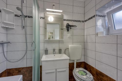 a white bathroom with a sink and a shower at Zea in Funtana