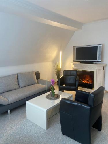 a living room with a couch and a fireplace at Pension / Ferienwohnung Allebrodt in Lennestadt