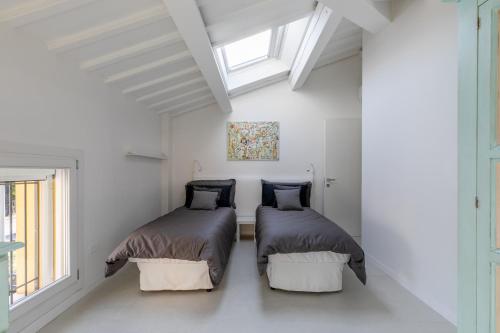 two beds in a white room with a window at The White House - business and charme in Padova