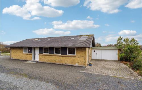 a brick house with a garage in a parking lot at 3 Bedroom Lovely Home In Vestervig in Vestervig