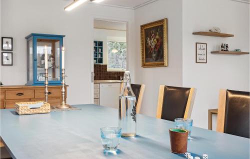 a dining room table with a bottle and glasses on it at 3 Bedroom Lovely Home In Vestervig in Vestervig