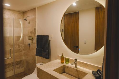 a bathroom with a sink and a shower at Exclusivo Departamento con vista a la marina in Conchal