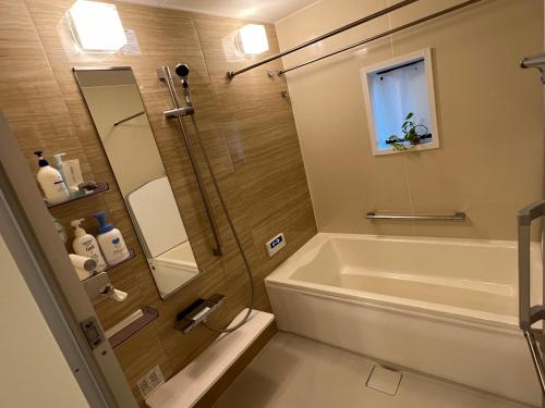 a bathroom with a shower and a tub and a sink at HomeStay 輝き Kagayaki ホスト在宅タイプ 一日一組限定 in Matsudo