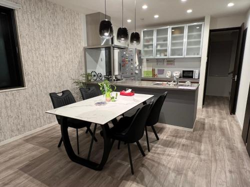 a kitchen and dining room with a table and chairs at HomeStay 輝き Kagayaki ホスト在宅タイプ 一日一組限定 in Matsudo