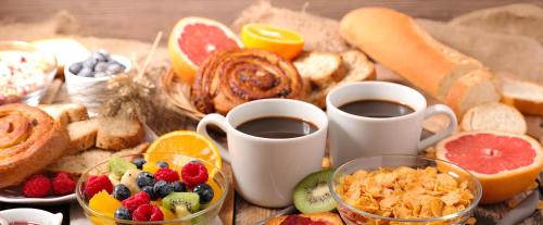 a table topped with cups of coffee and breakfast foods at Inn Rhome S Pietro Suites in Rome