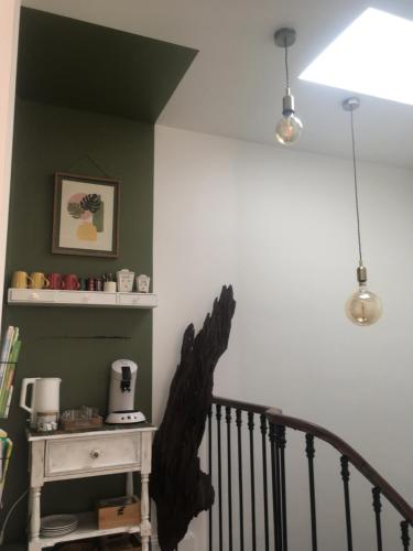 un escalier avec une statue d'oiseau noir sur le mur dans l'établissement La Canopée, à Bordeaux