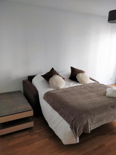 - un lit avec des draps et des oreillers marron et blanc dans l'établissement Chez Charlotte, à Chessy