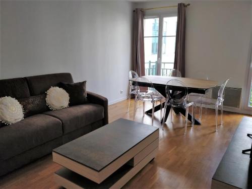 un salon avec un canapé et une table dans l'établissement Chez Charlotte, à Chessy