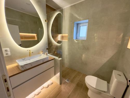 a bathroom with a toilet and a sink and a mirror at Villa Cecilia Luxury Stay in Kastoria