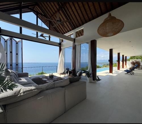 a living room with a couch and a view of the ocean at Villa Salama in Tanjung