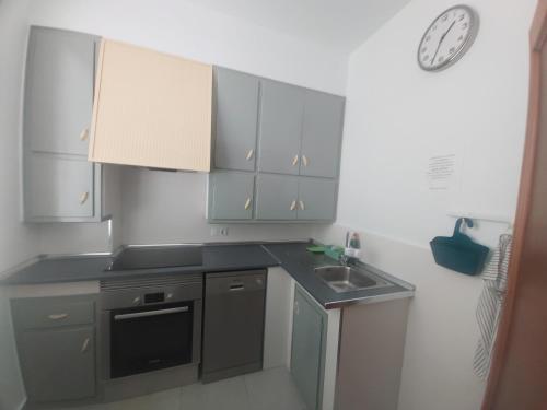 a kitchen with a sink and a clock on the wall at Salvador House II in Elche