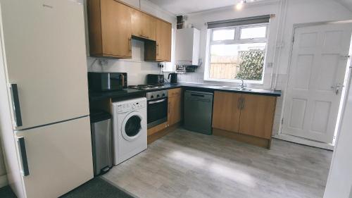 a kitchen with a white refrigerator and a washer at Dwellcome Home Ltd 3 DOUBLE Bedroom House Boldon, Ideal for long term contractor, etc stays, Free Parking, Fast WIFI, 3 miles 7 mins drive to Nissan, 15 mins to Sunderland Newcastle, Regular Housekeeping Options - see our site for assurance in Boldon
