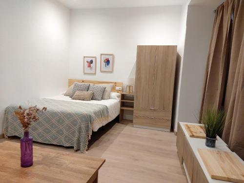 a bedroom with a bed with a purple vase at Salvador House I in Elche