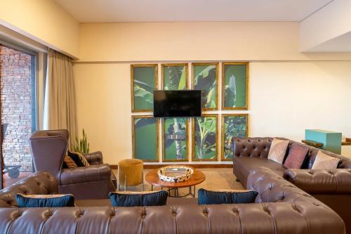 a living room with two couches and a tv at Kabira Country Club in Kampala