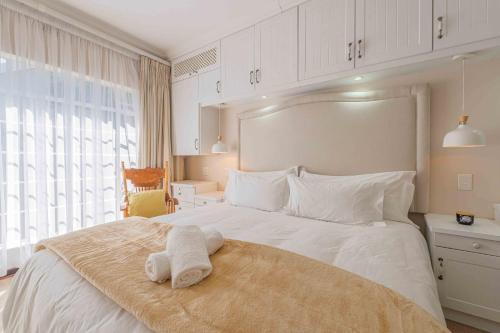 a bedroom with a white bed with a towel on it at The Manor at Chaplin Manor in Johannesburg