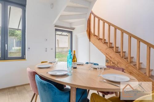 une salle à manger avec une table en bois et des chaises bleues dans l'établissement Charmante Maisonnette avec Jardin, Parking Privé à Proximité d'Eurexpo, à Saint-Priest