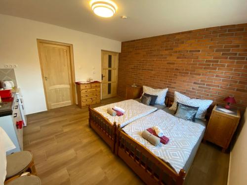 a bedroom with a bed with a brick wall at Veronka Vendékház Gombosszeg in Gombosszeg