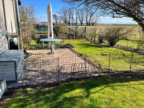 a fence with a table in a yard at Ferienwohnung Thees in Ummanz