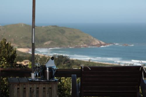 a table with a view of the ocean on a hill at Bangalore Suites in Garopaba