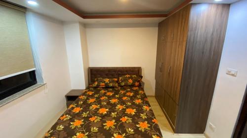 a bedroom with a bed and a wooden cabinet at Suite Stay in Kathmandu