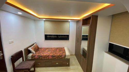a small room with a bed and a window at Suite Stay in Kathmandu