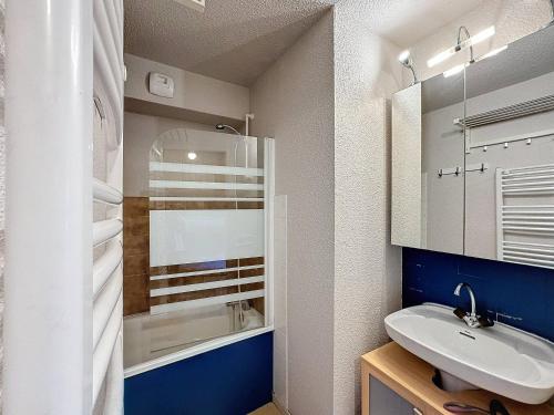 une salle de bain avec un lavabo et une baignoire dans l'établissement Beau T2 4 pers 24m² ski aux pieds, idéal pour les vacances - FR-1-178-139, aux Menuires