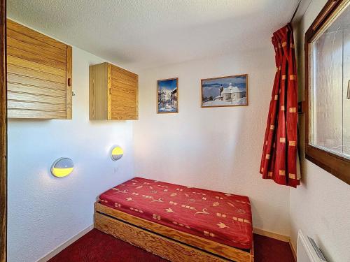 Cette petite chambre comprend un banc rouge. dans l'établissement Appartement 2 pièces + coin montagne, 26m², 5 pers, Wi-Fi, ski aux pieds, Les Menuires - FR-1-178-92, aux Menuires