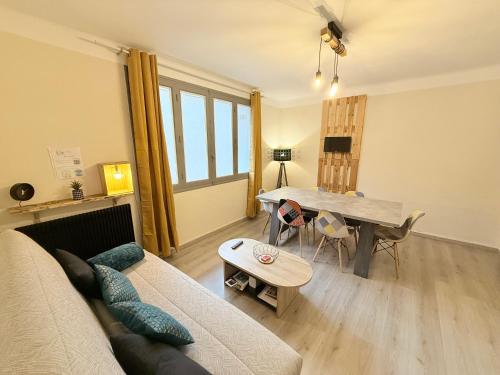 un salon avec un canapé et une table dans l'établissement Les Arènes de Nîmes - Centre ville 10 min Gare -Parking- 2 chambres, à Nîmes