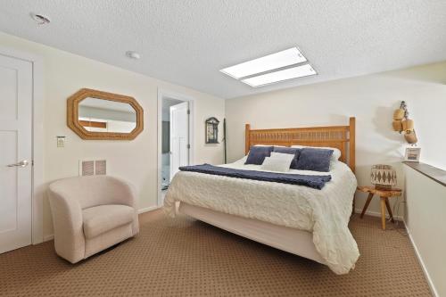 a bedroom with a bed and a chair and a mirror at 342 Edgewater Inn in Charlevoix