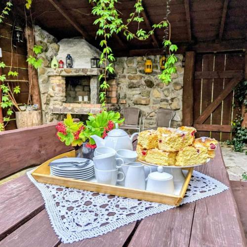 a table with a tray of food on a wooden deck at Piecówka Wysokie Kaczki in Kaczkowo
