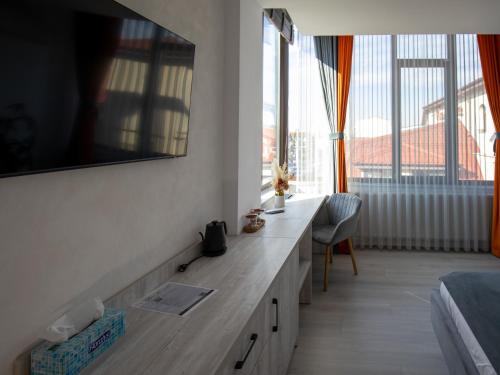 a bedroom with a desk and a large window at Casa Muntenească Alessandro in Piteşti