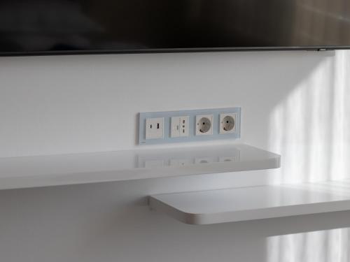 a white shelf with two electrical outlets on a wall at Casa Muntenească Alessandro in Piteşti