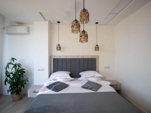 a bedroom with a large bed and pendant lights at Casa Muntenească Alessandro in Piteşti