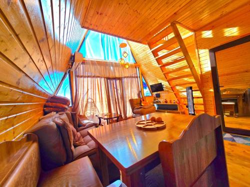 a living room with a wooden table in a cabin at Mountain Star in Batumi