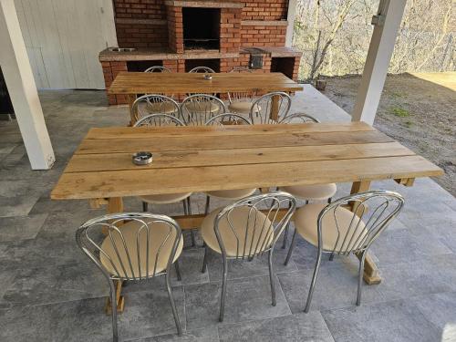a wooden table and some chairs and a fireplace at Casa Dragoste in Someşu Cald