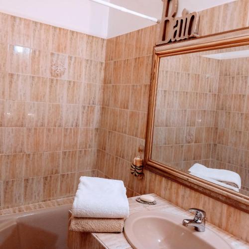 une salle de bain avec un lavabo, un miroir et une baignoire dans l'établissement Appartement au coeur du centre historique, à Narbonne