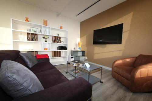 - un salon avec un canapé et une télévision dans l'établissement Le 360 TOUR PERRET 19eme PANORAMA 4 ETOILES, à Amiens