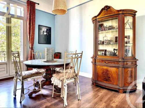 une salle à manger avec une table et une grande armoire en bois dans l'établissement Chez Grace, à Cannes
